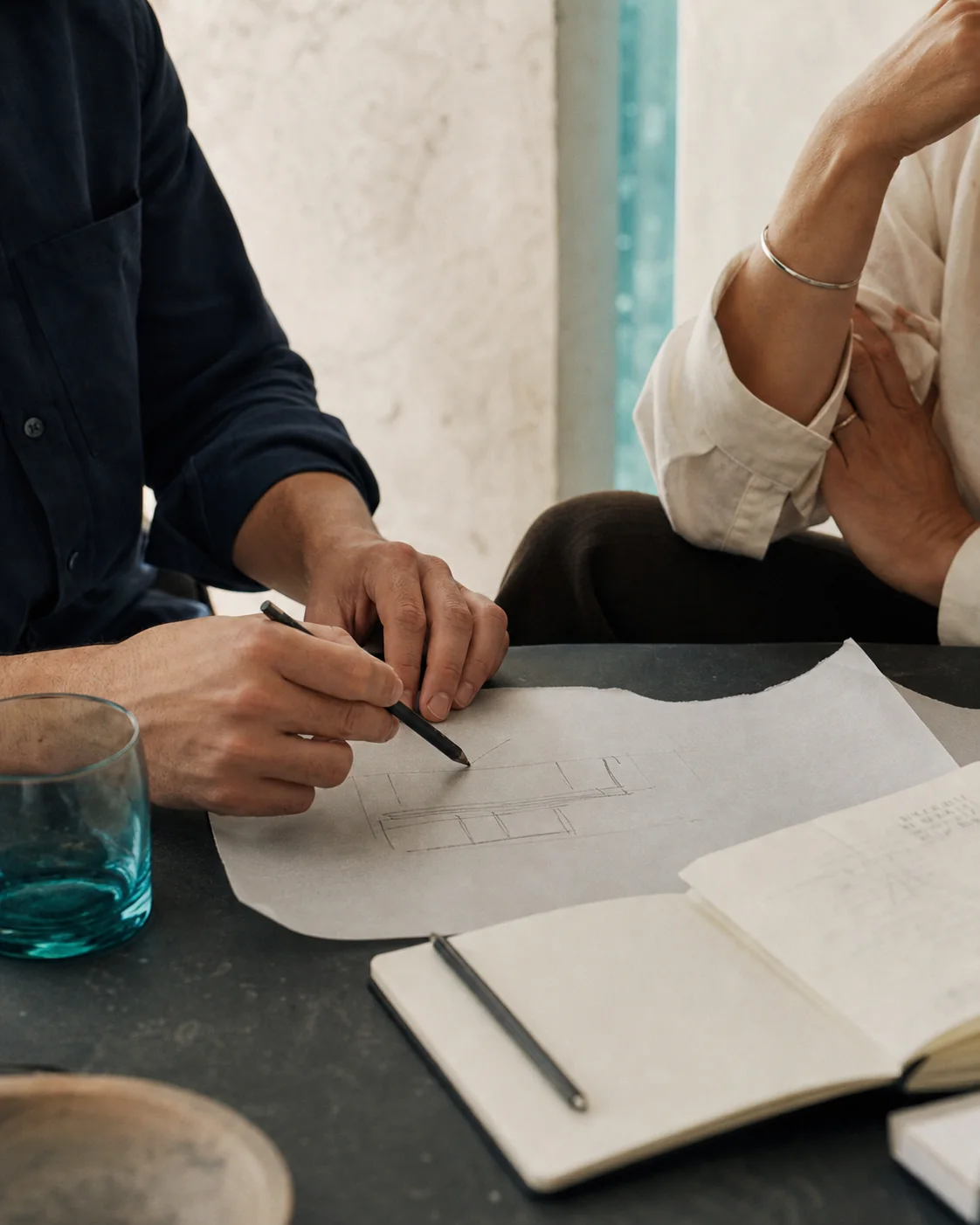 Dos personas dibujando una idea en papel durante una conversación de trabajo